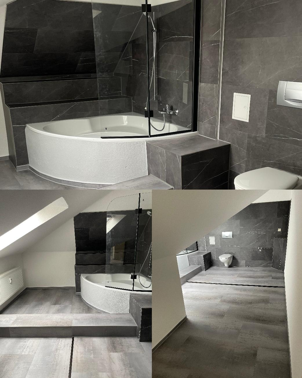 Fertig modernisiertes Dachbad mit dunklen Großformatfliesen, Eckbadewanne und Glasabtrennung
