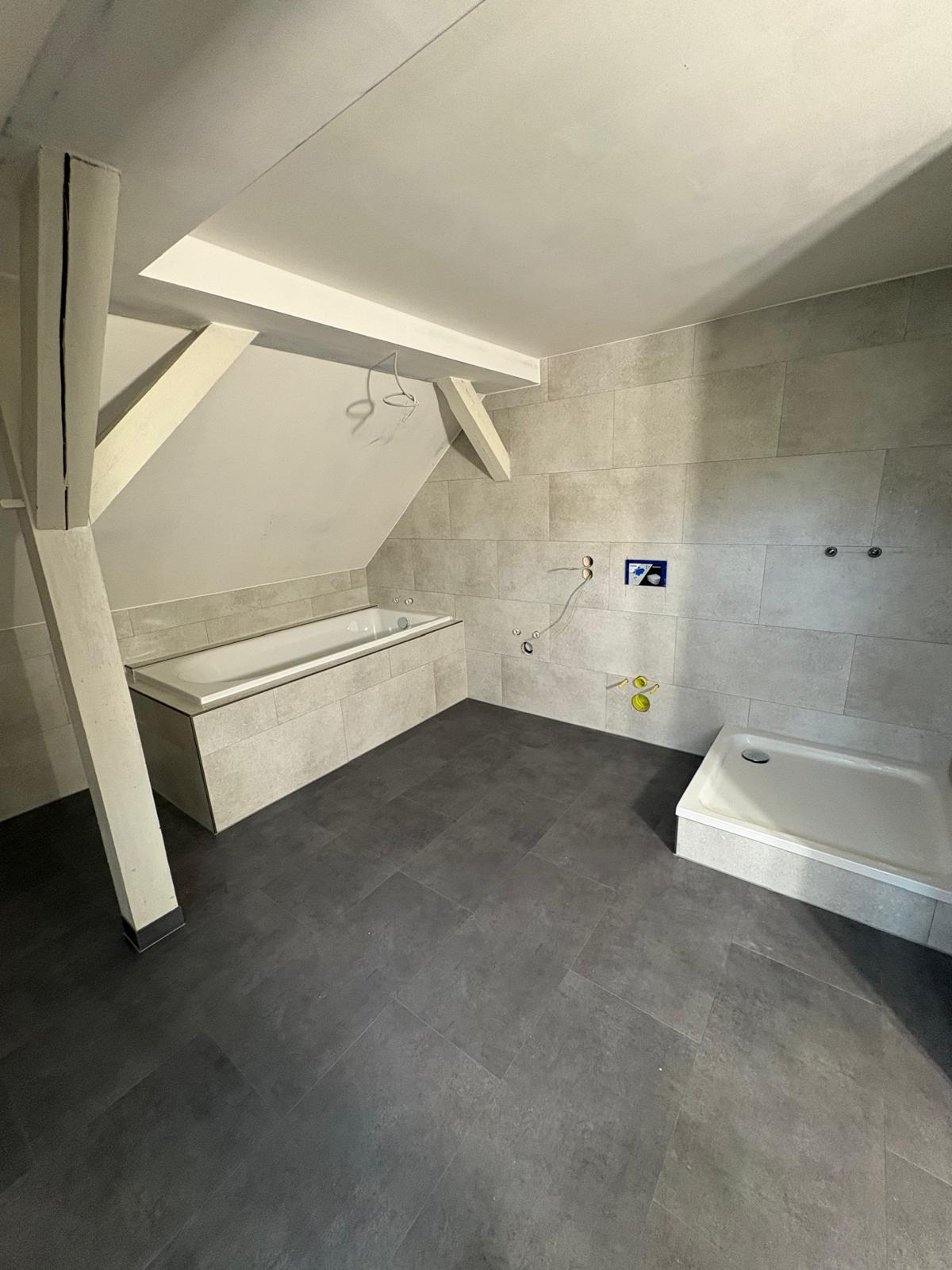 Modernes Dachgeschossbad mit Badewanne, Dusche und grauen Fliesen