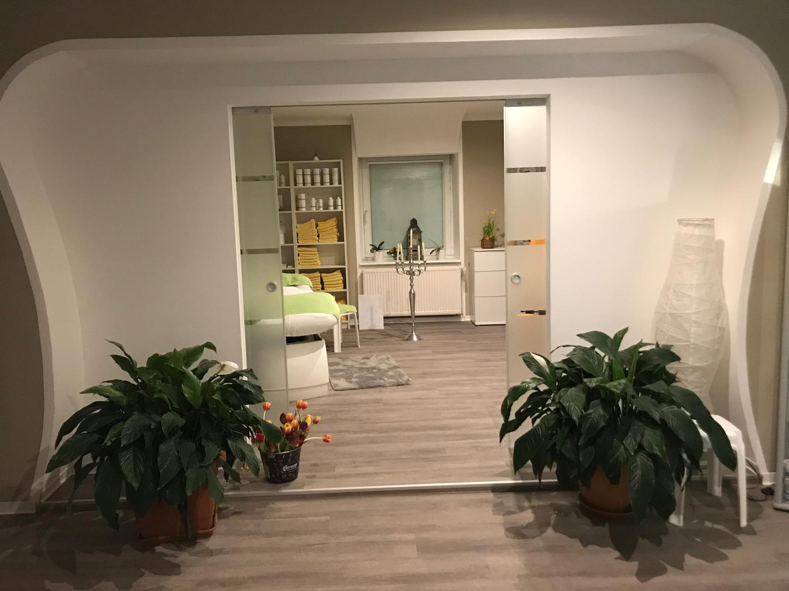 Fertig renoviertes Studio mit breitem weißen Wanddurchgang, Glas-Schiebetür und grauem Boden