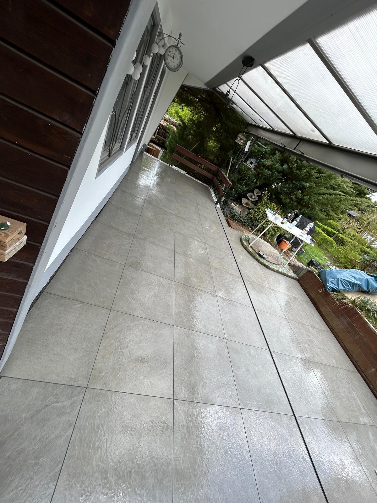 Graue Terrassenplatten mit gerader Entwässerungsrinne über die Außenfläche