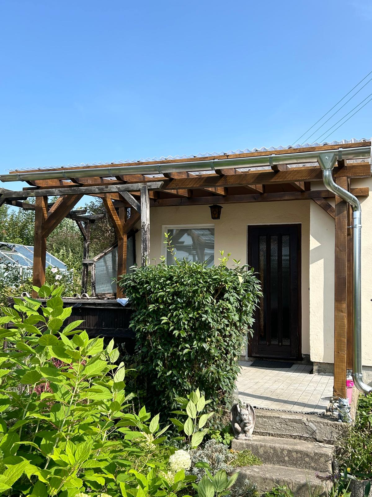 Fertiggestellte Terrassenüberdachung aus Holz mit transparenter Eindeckung