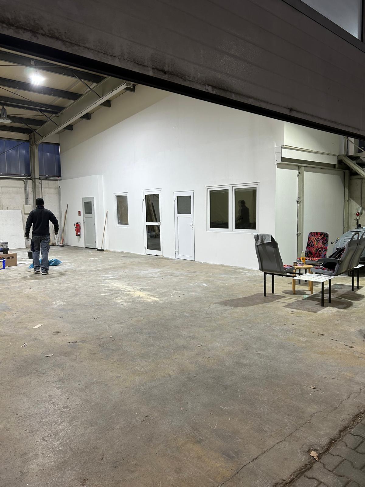 Fertiggestellter Raum-in-Raum-Ausbau in einer Gewerbehalle mit Fenstern und Türen