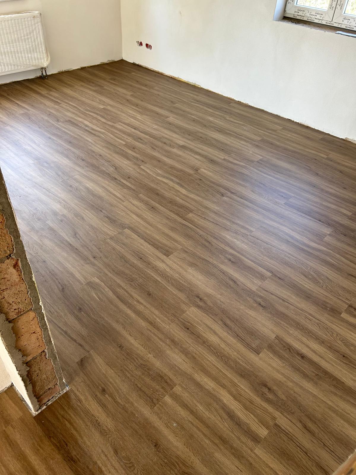 Neu ausgebauter Wohnraum mit gleichmäßig verlegtem Vinylboden in warmer Holzoptik